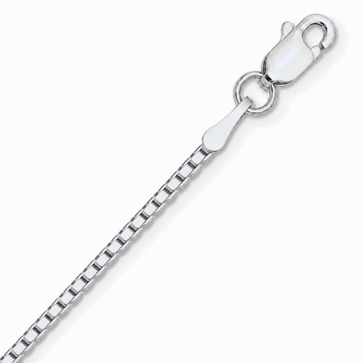 A close up image of a white gold box chain on a pure white background