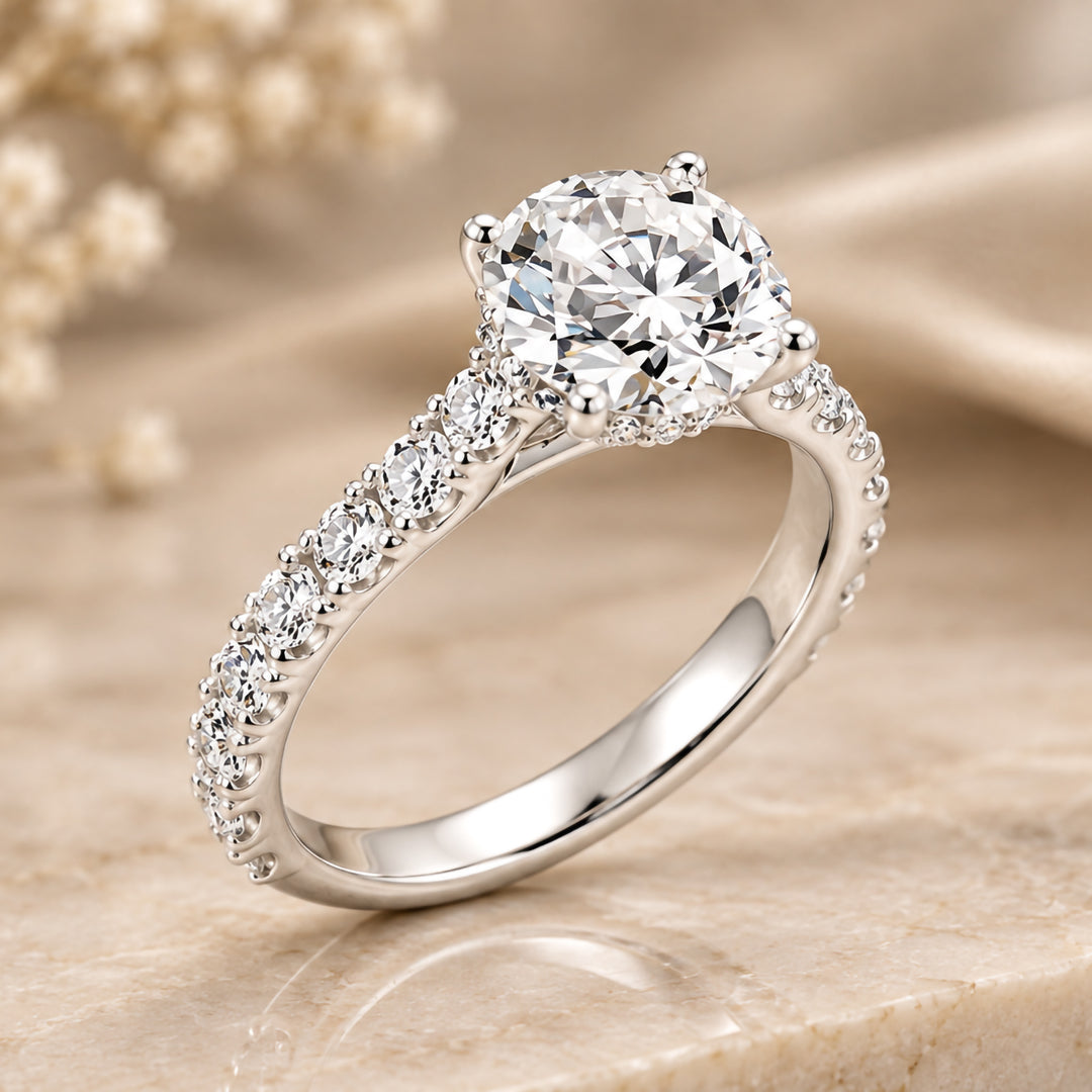 14 karat white gold 3ct round lab grown diamond hidden halo engagement ring with diamond accent band shown at an angle on a styled display at AJ's Jewelry in Ridgewood, Queens NY