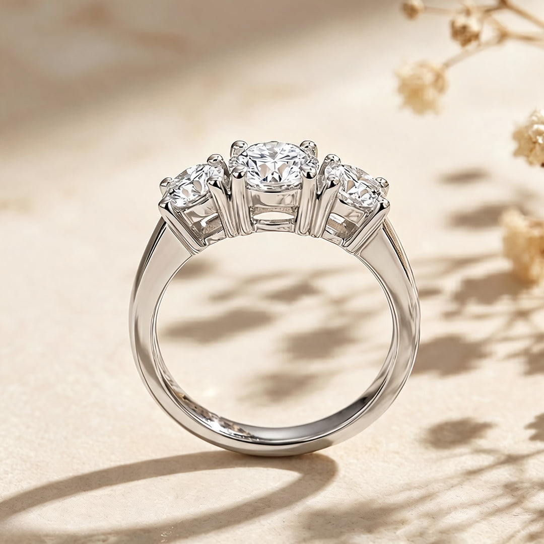 14 karat white gold lab grown diamond three-stone anniversary ring shown from the side on a styled display at AJ's Jewelry in Ridgewood, Queens NY