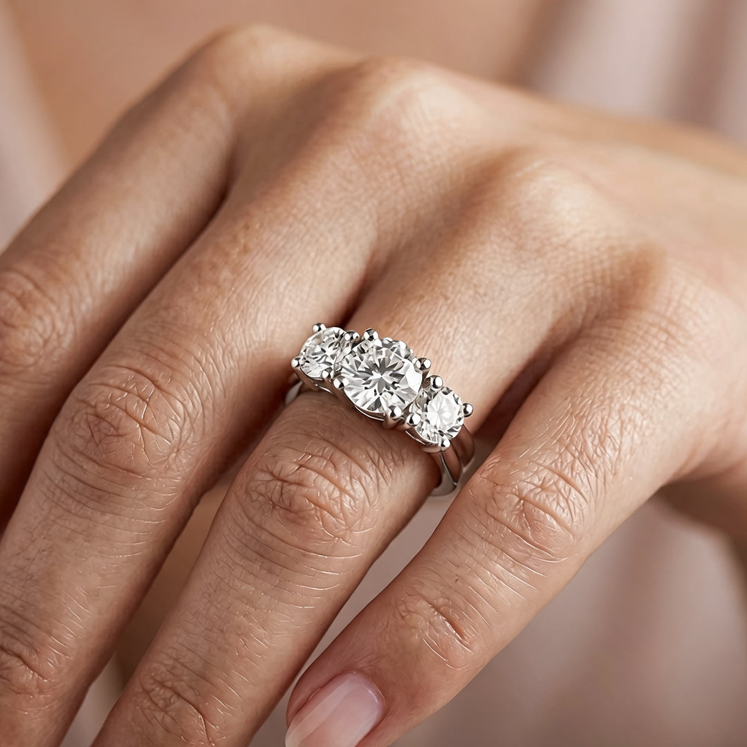 14 karat white gold lab grown diamond three-stone anniversary ring worn on a hand at AJ's Jewelry in Ridgewood, Queens NY