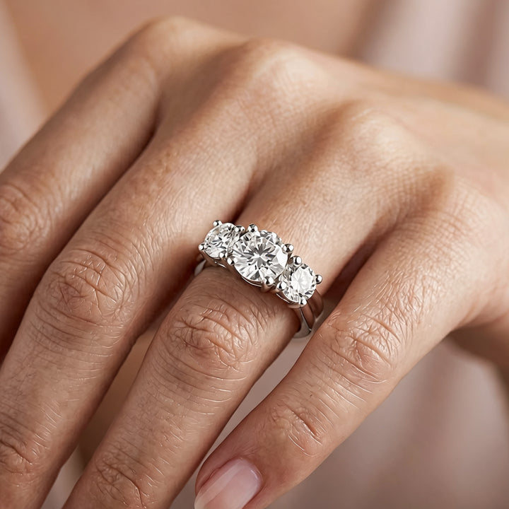 14 karat white gold lab grown diamond three-stone anniversary ring worn on a hand at AJ's Jewelry in Ridgewood, Queens NY