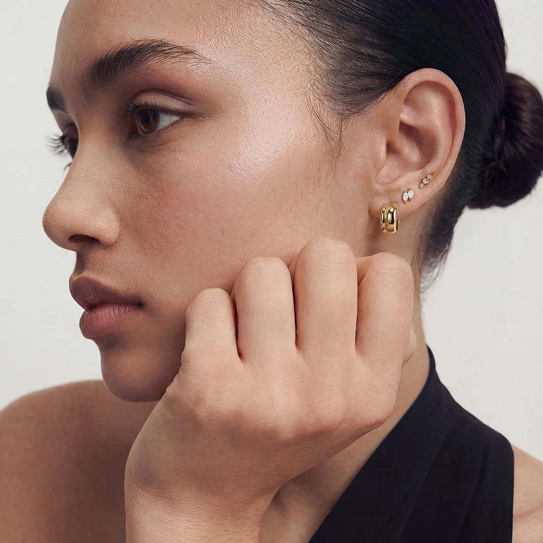 Model in profile wearing the 14K yellow gold double marquise lab grown diamond stud earrings with other gold earrings | AJ's Jewelry