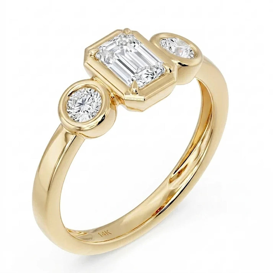 14K yellow gold three-stone bezel ring with an emerald-cut lab grown diamond center and two round lab grown diamonds