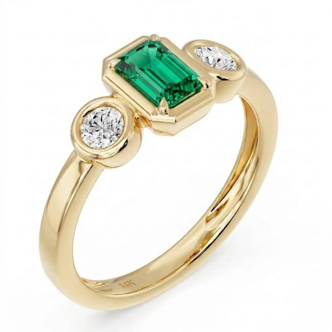 14K yellow gold three-stone bezel ring with an emerald-cut lab created emerald center and two round lab grown diamonds