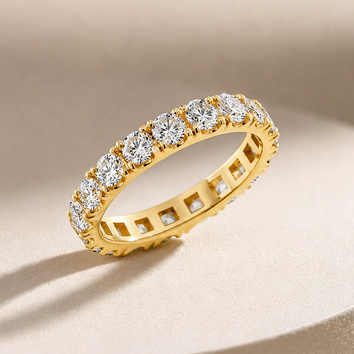 14 karat yellow gold lab grown diamond eternity band shown at an angle on a styled display at AJ's Jewelry in Ridgewood, Queens NY