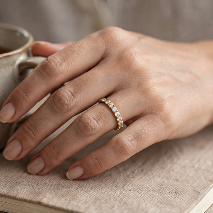 14 karat yellow gold lab grown diamond eternity band worn on a hand at AJ's Jewelry in Ridgewood, Queens NY