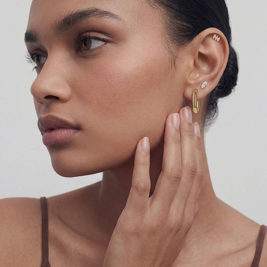The 14K yellow gold marquise lab grown diamond three-stone flat back stud earrings shown on a model in profile | AJ's Jewelry