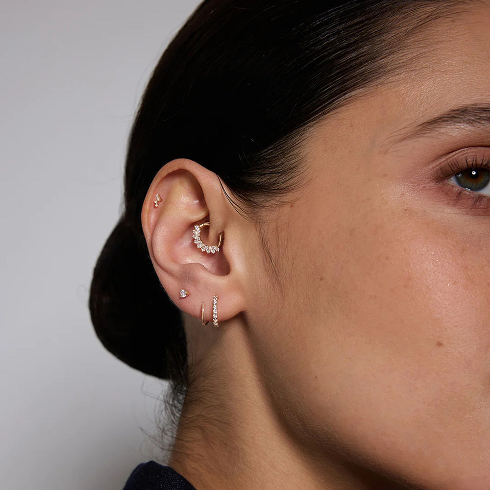 Model wearing the 14K yellow gold natural diamond curved cluster flat back stud earrings in a styled ear stack | AJ's Jewelry