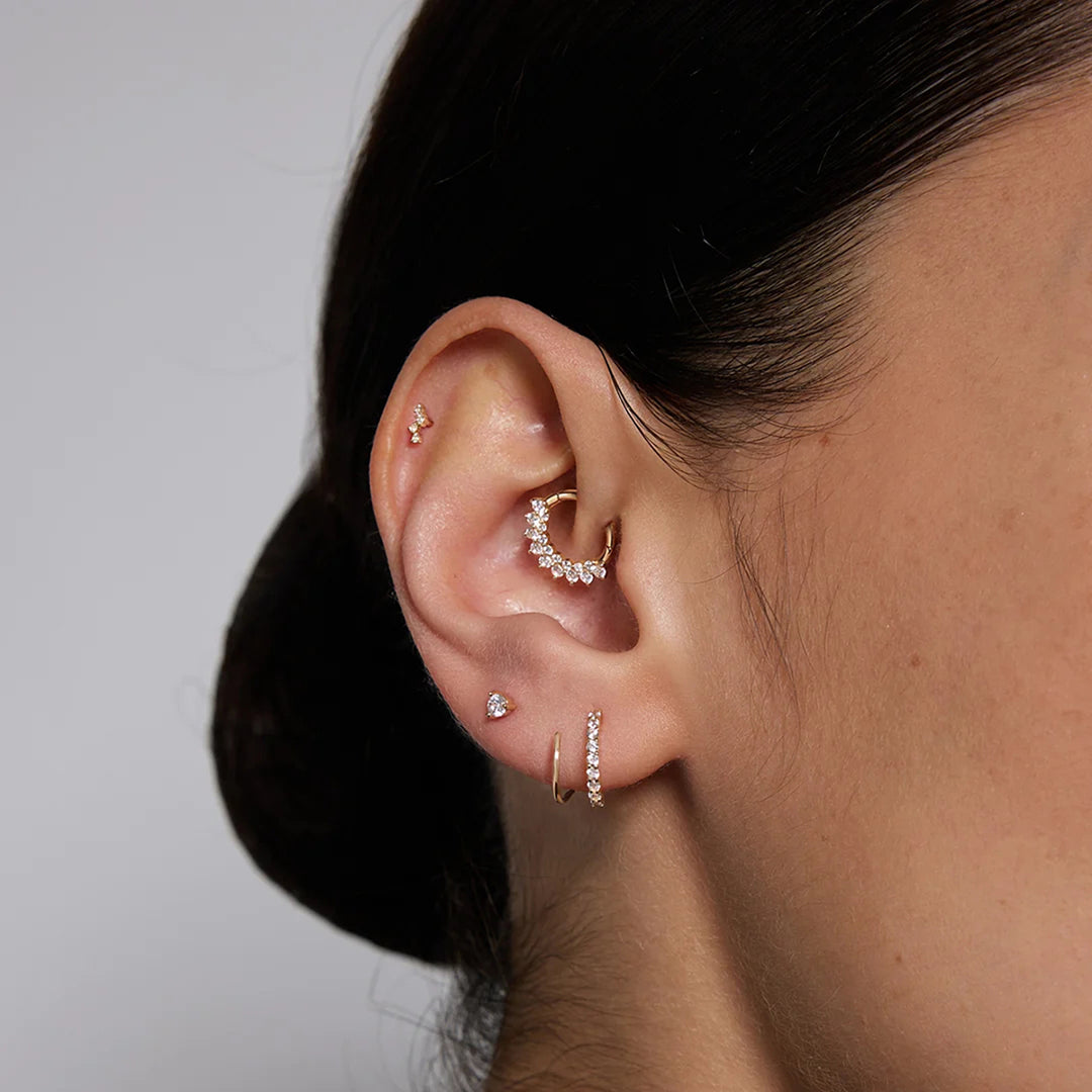 Close-up of the 14K yellow gold natural diamond curved cluster flat back stud earrings worn on the ear | AJ's Jewelry