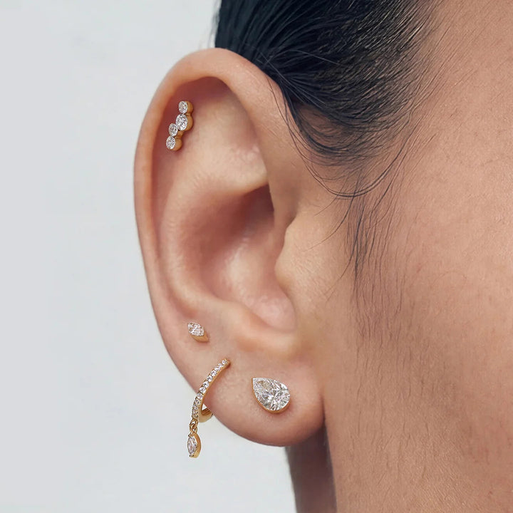 Close-up of the 14K yellow gold pear lab grown diamond flat back stud earrings worn on the ear | AJ's Jewelry