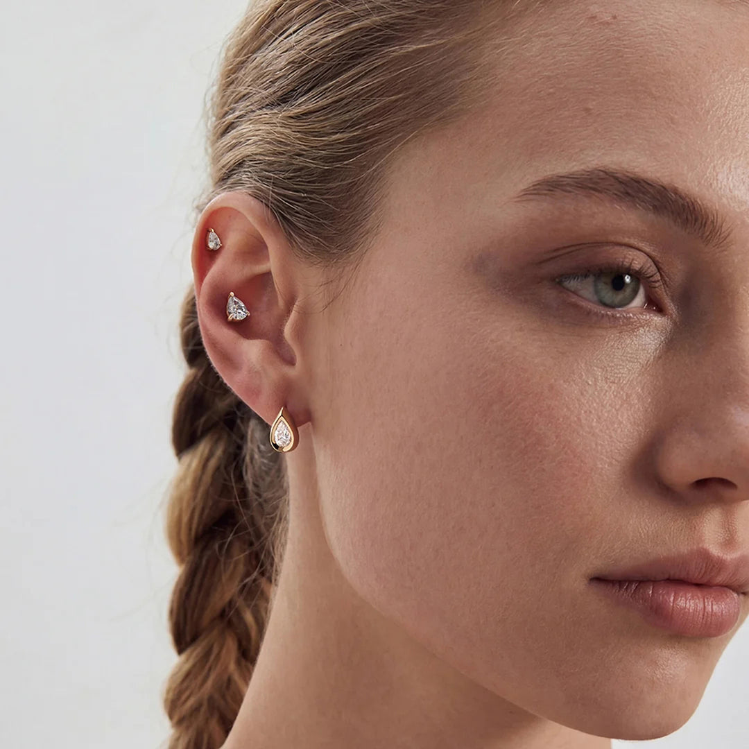 Model wearing the 14K yellow gold pear lab grown diamond stud earrings with layered fine jewelry | AJ's Jewelry