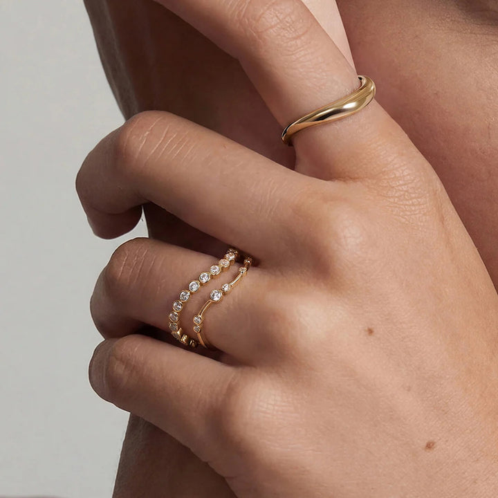 Close-up of the 14K yellow gold polished curved wave band ring worn on the hand | AJ's Jewelry