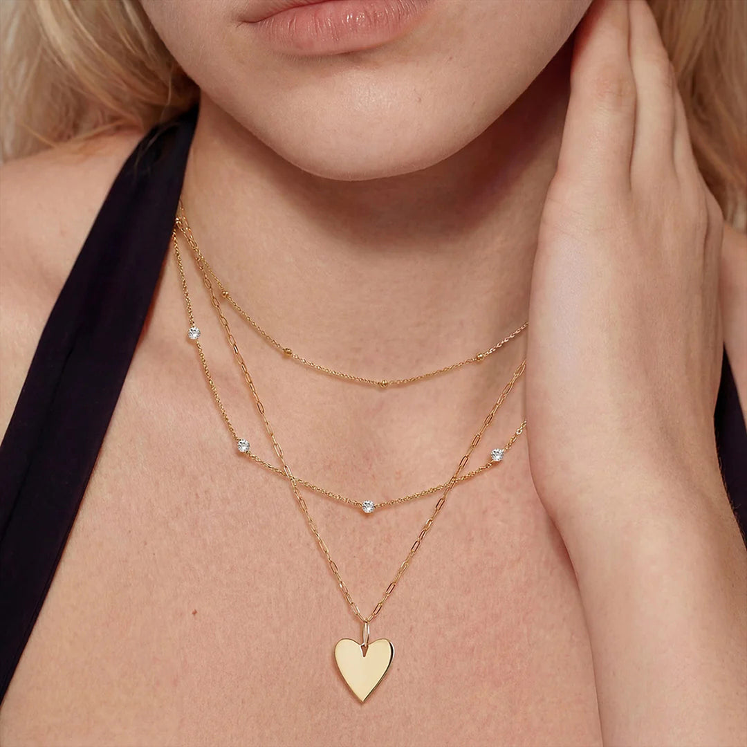 The 14K yellow gold polished heart pendant necklace shown on a model | AJ's Jewelry