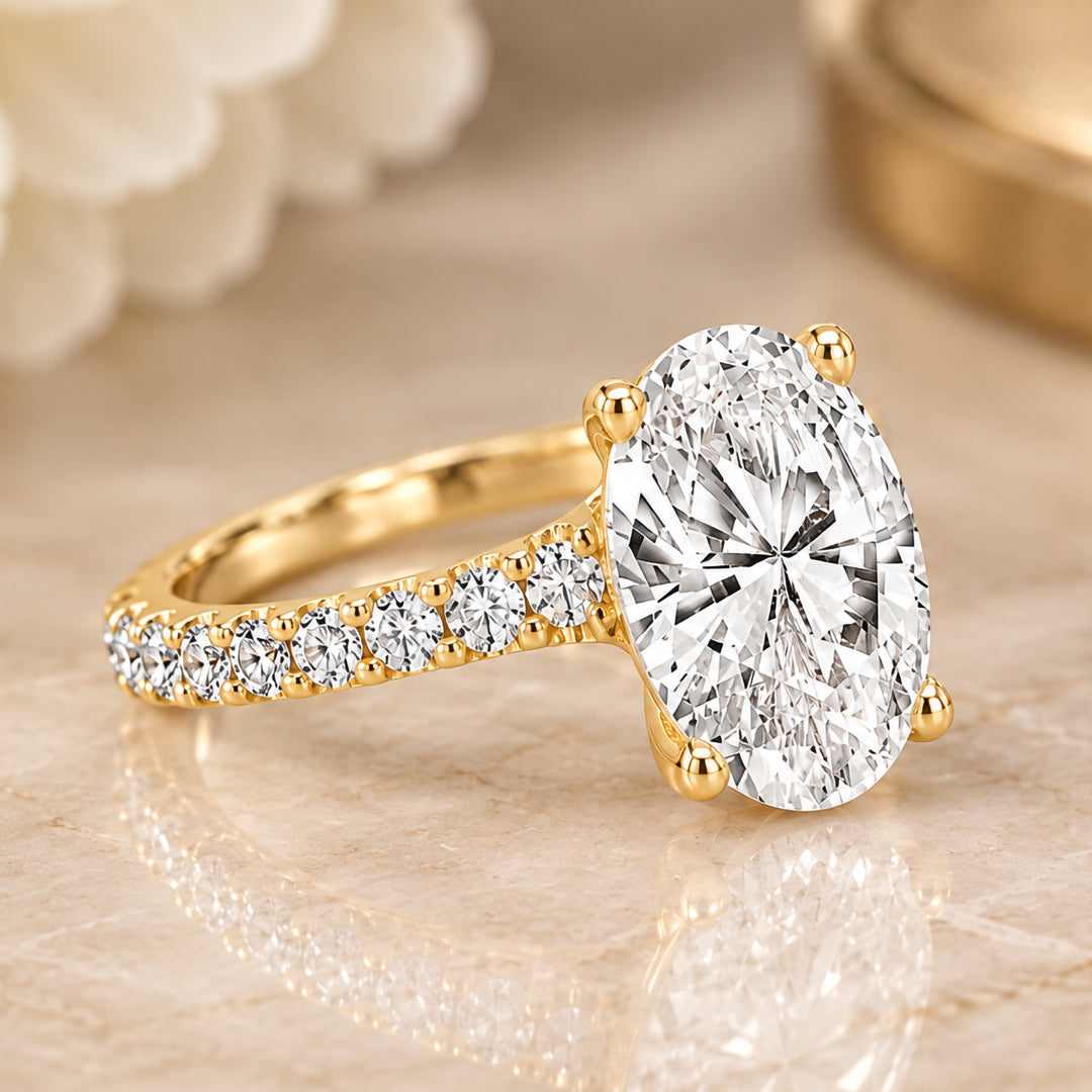 Angled view of the 2ct oval lab grown diamond held in four prongs on a 14 karat yellow gold diamond band
