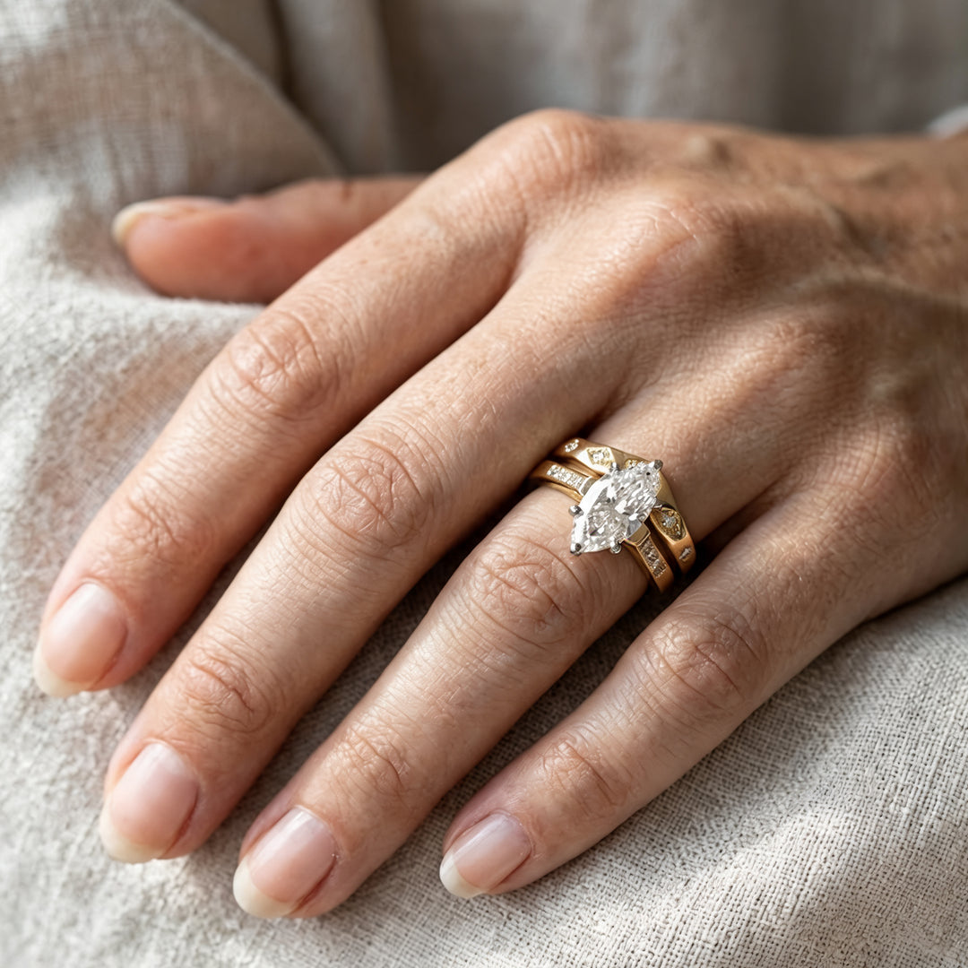 14k yellow gold lab grown diamond chevron wedding band nested against a marquise engagement ring, worn on a hand - AJ's Jewelry Ridgewood Queens NY