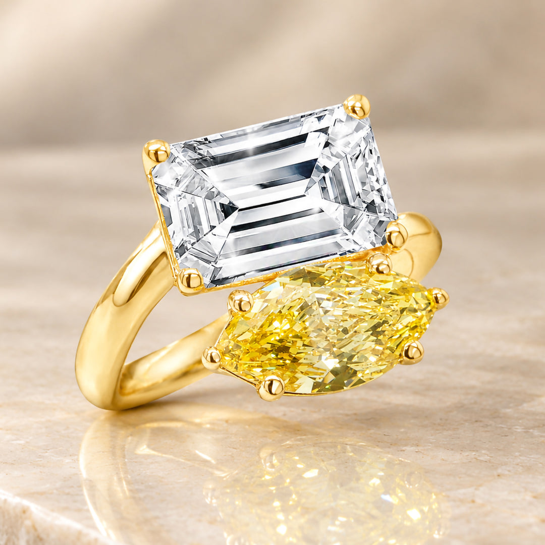 Angled view of the two-stone lab grown diamond engagement ring in 14 karat yellow gold, the fancy vivid yellow marquise set beside the white diamond