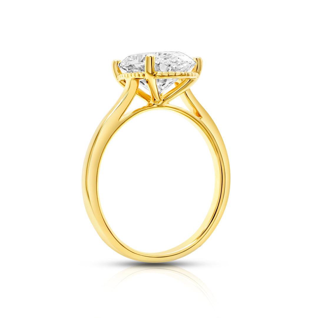 Side profile of a 3ct oval lab grown diamond solitaire showing the milgrain beaded detail along the halo rail in 14k yellow gold - AJ's Jewelry Queens NY