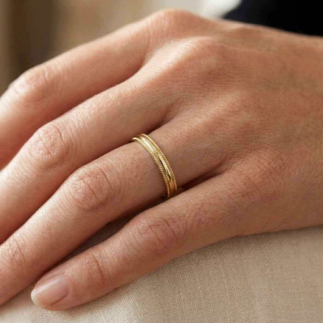 A model wearing the 3mm Yellow Gold Comfort Fit Milgrain Wedding Band