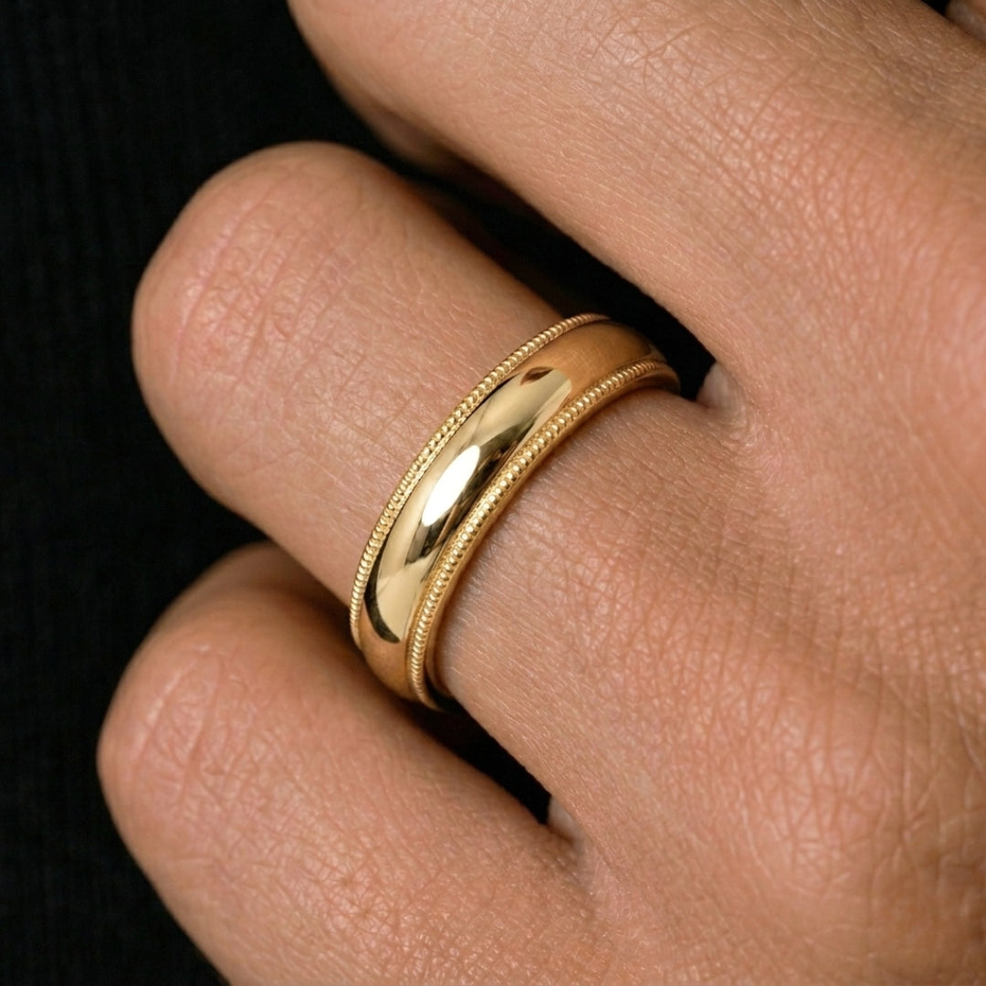 A model wearing the 5mm Yellow Gold Comfort Fit Milgrain Wedding Band