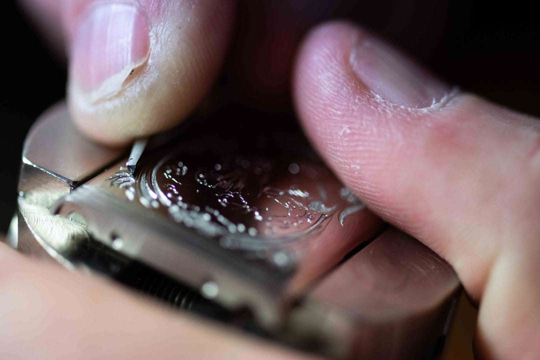 Man hand engraving a piece of jewelry