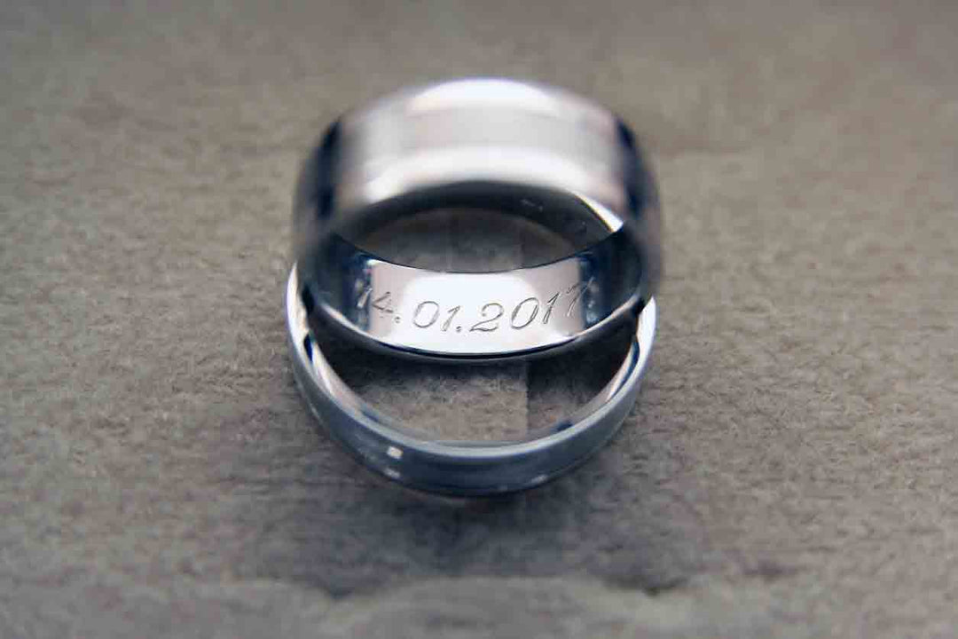 Two engraved rings sitting on a table.