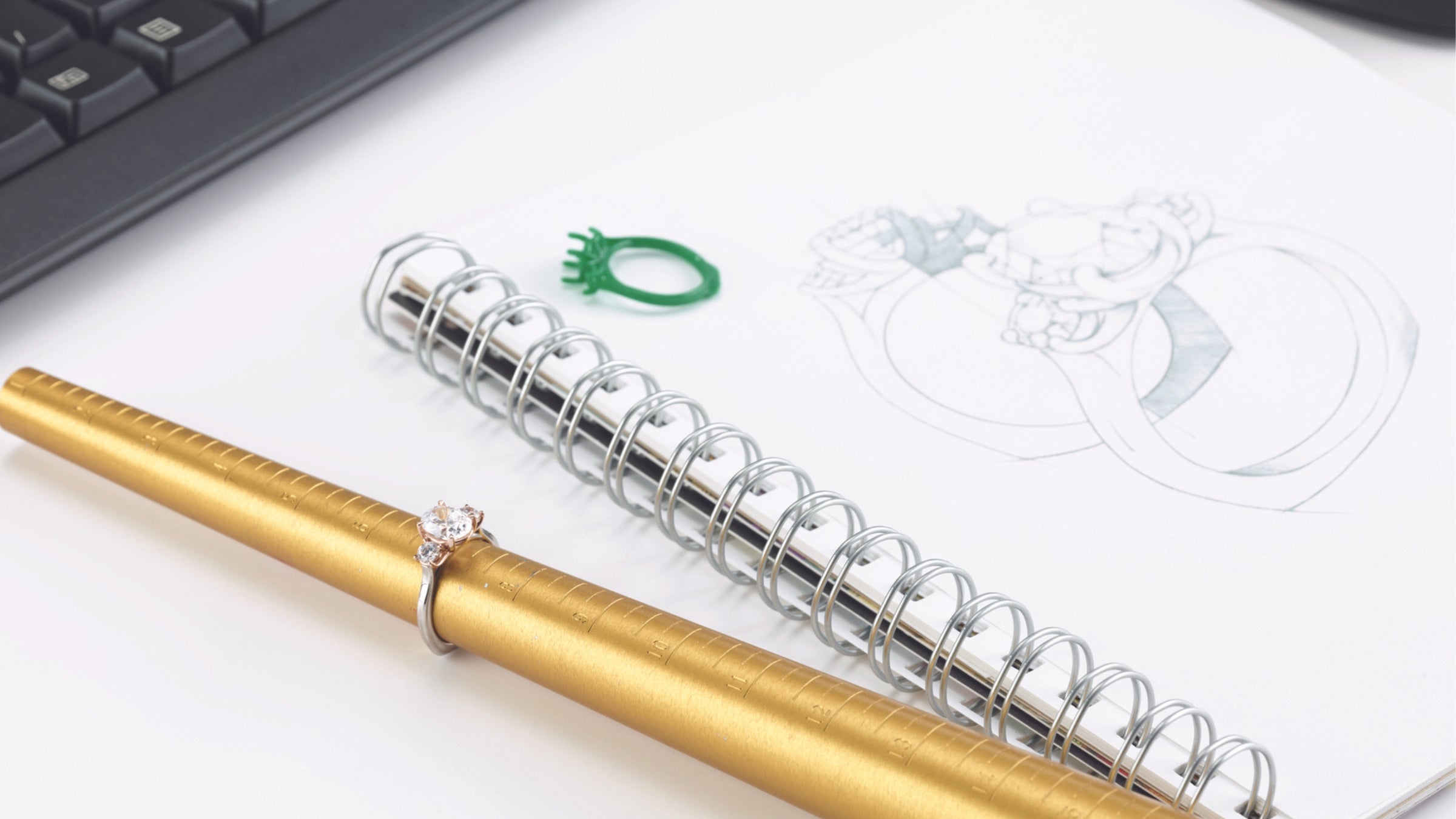 An image showing a custom jewelry design sketch and finished product with tools