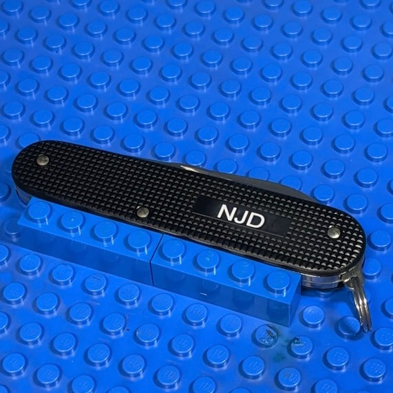 An image showing a pocket knife engraved with someone's initials