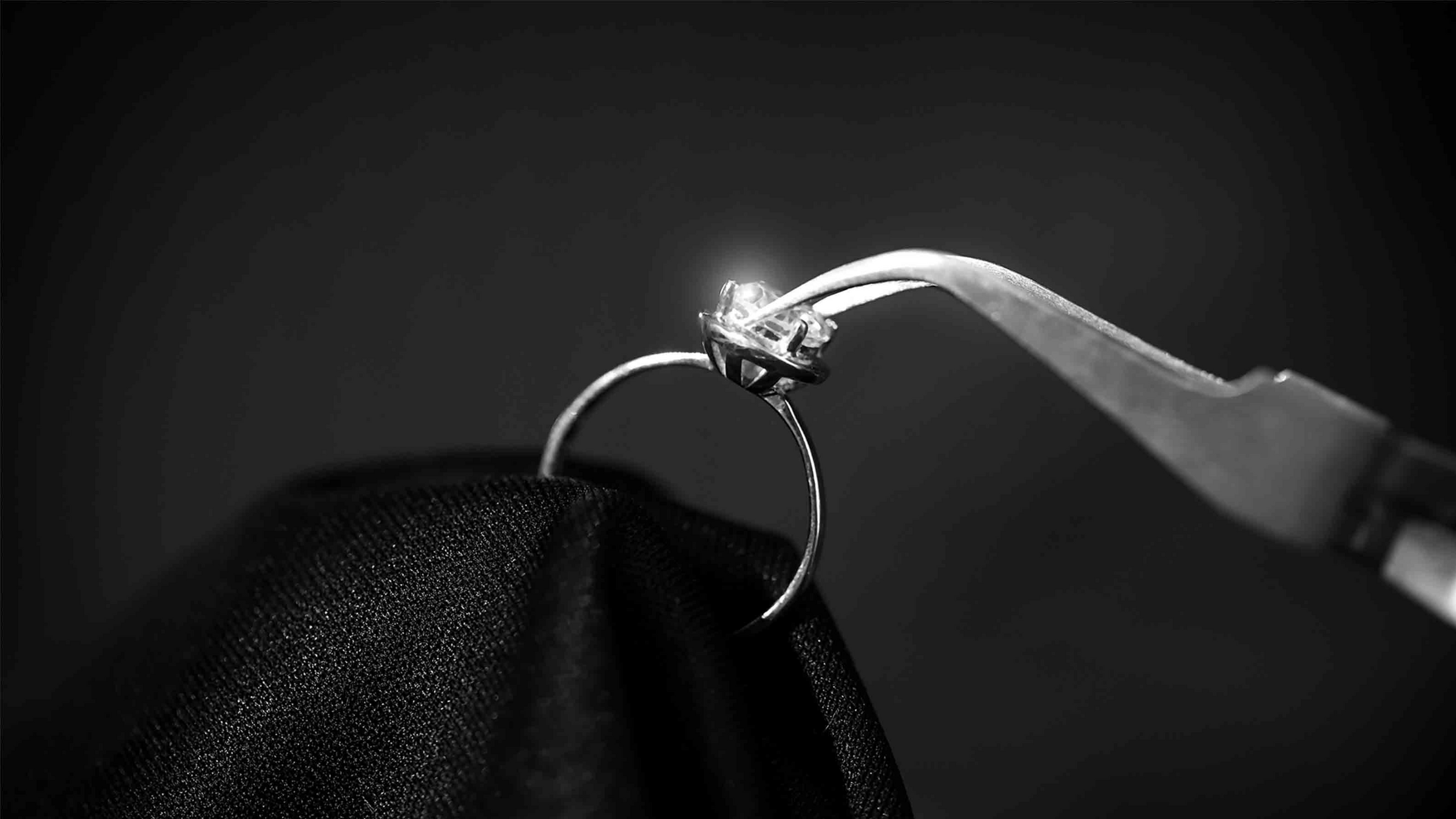 A jeweler setting a center stone on an engagement ring