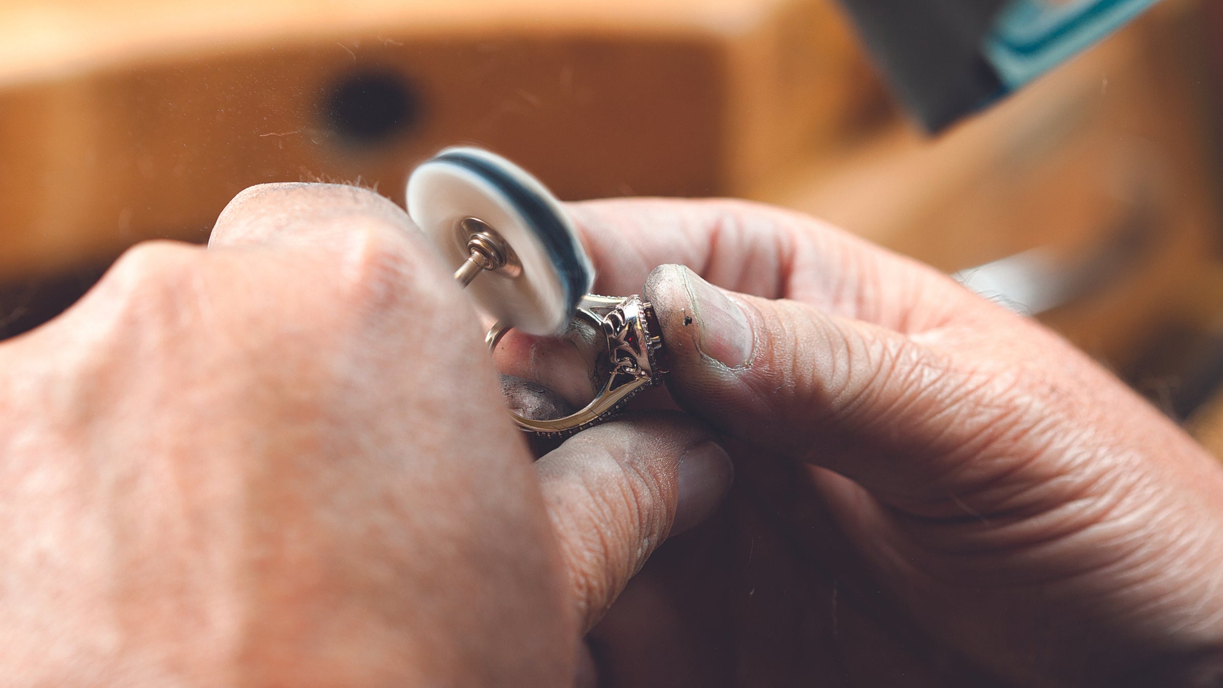 A bench jeweler polishing a ring