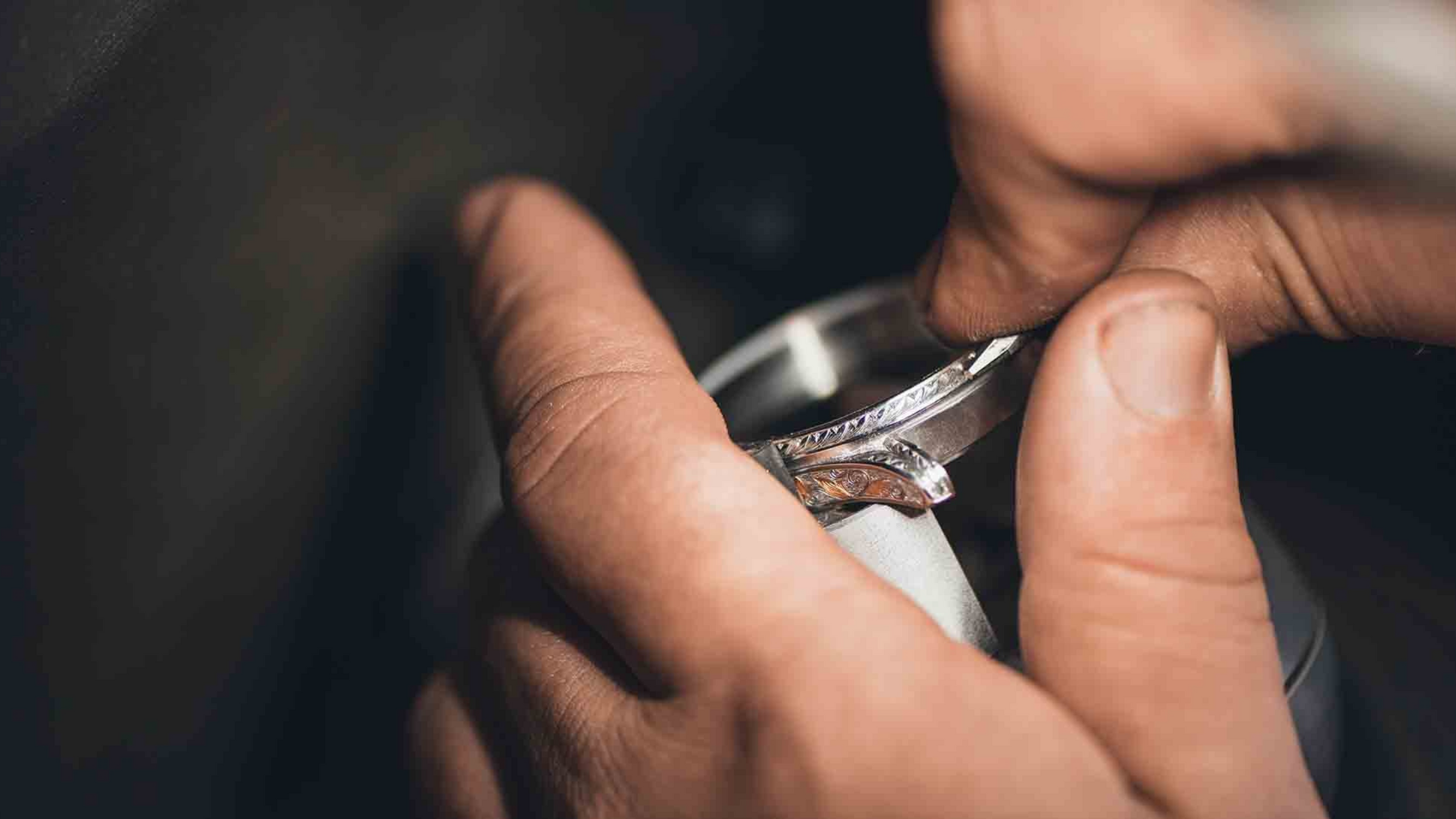 A jeweler engraving on a ring