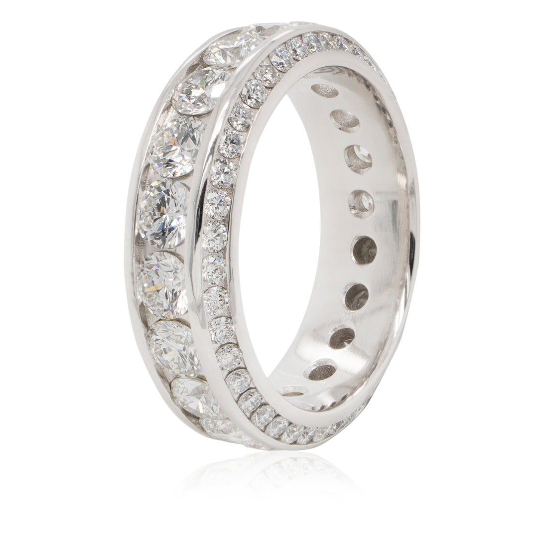 White gold diamond band ring veritacally positioned on a white background