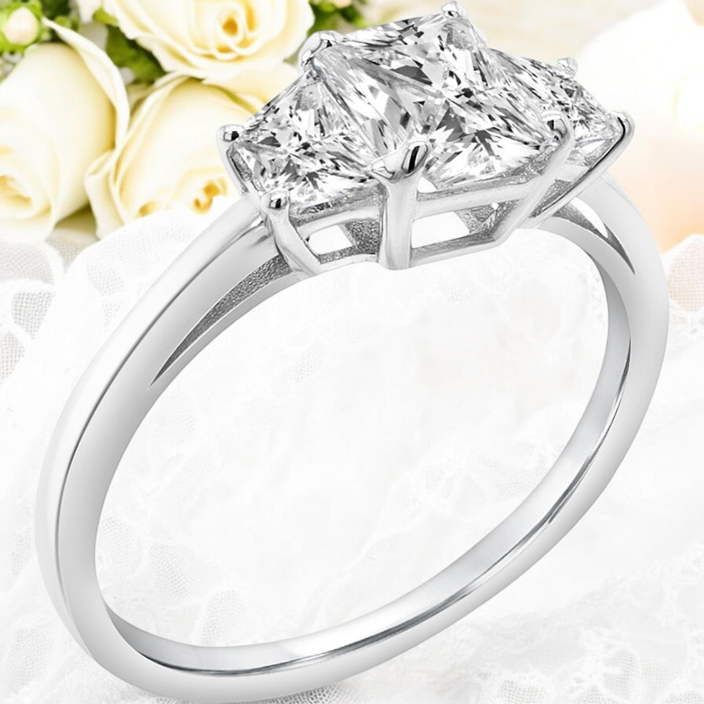 An image showing a finished version of the 3-stone engagement ring on a floral background