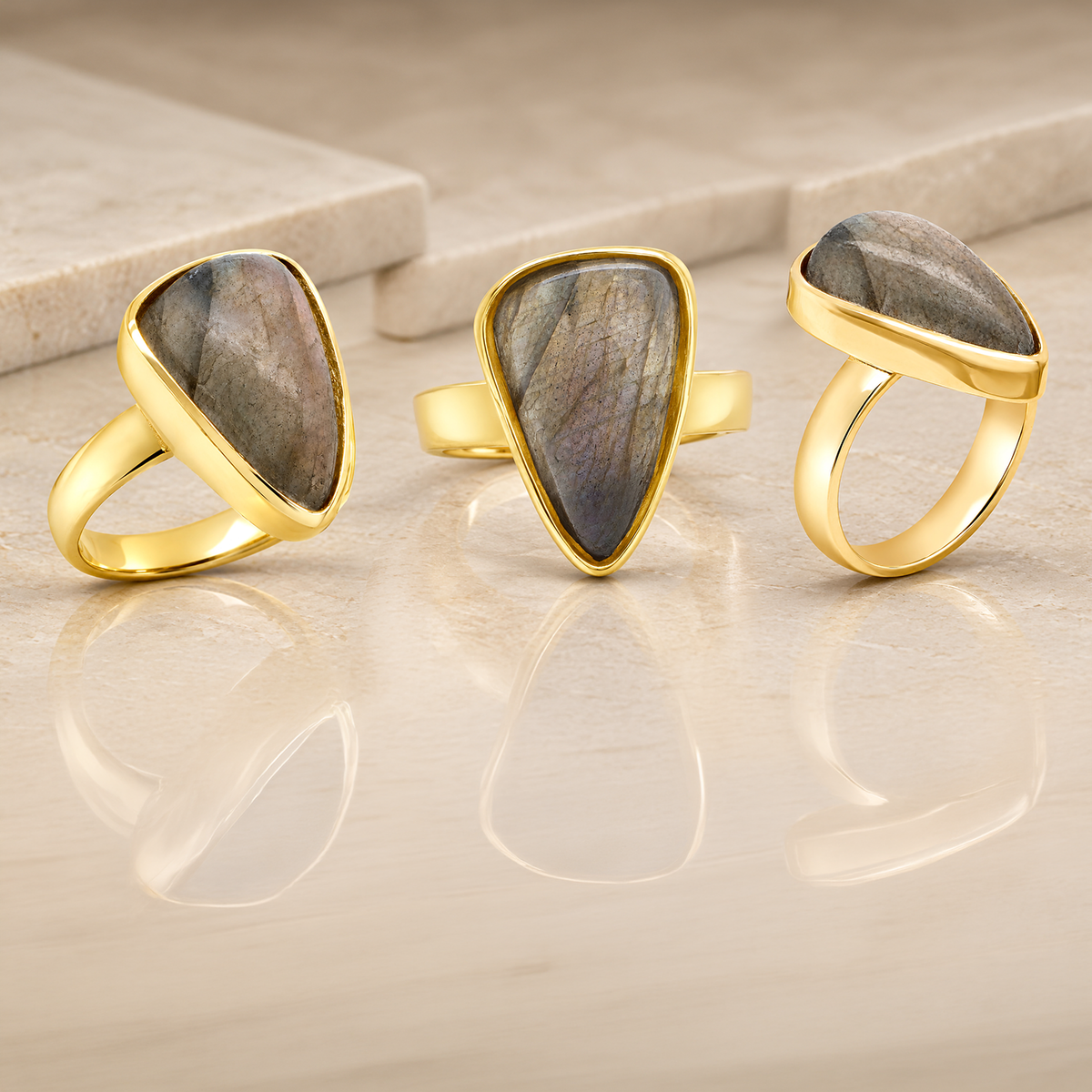 Custom 14 karat yellow gold pear shaped labradorite ring shown from three angles, made at AJ's Jewelry in Ridgewood Queens