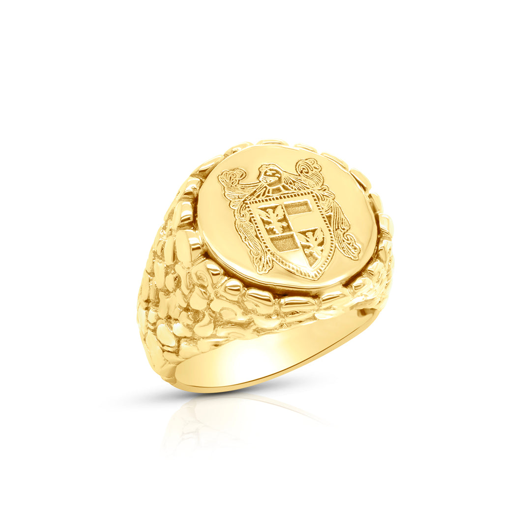 Gold signet ring with a detailed family crest emblem on a white background