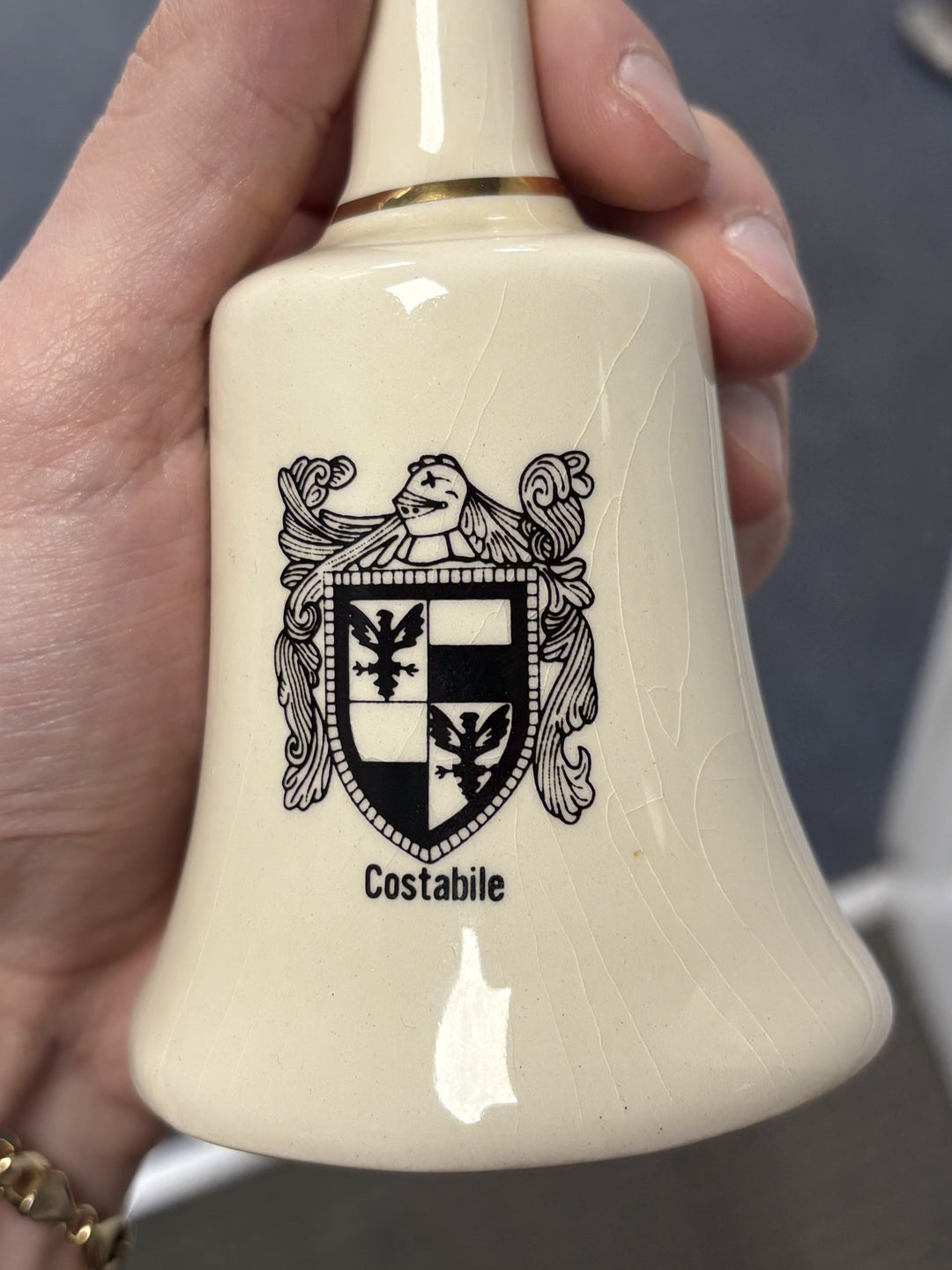 Ceramic bell with a black toned family crest on it