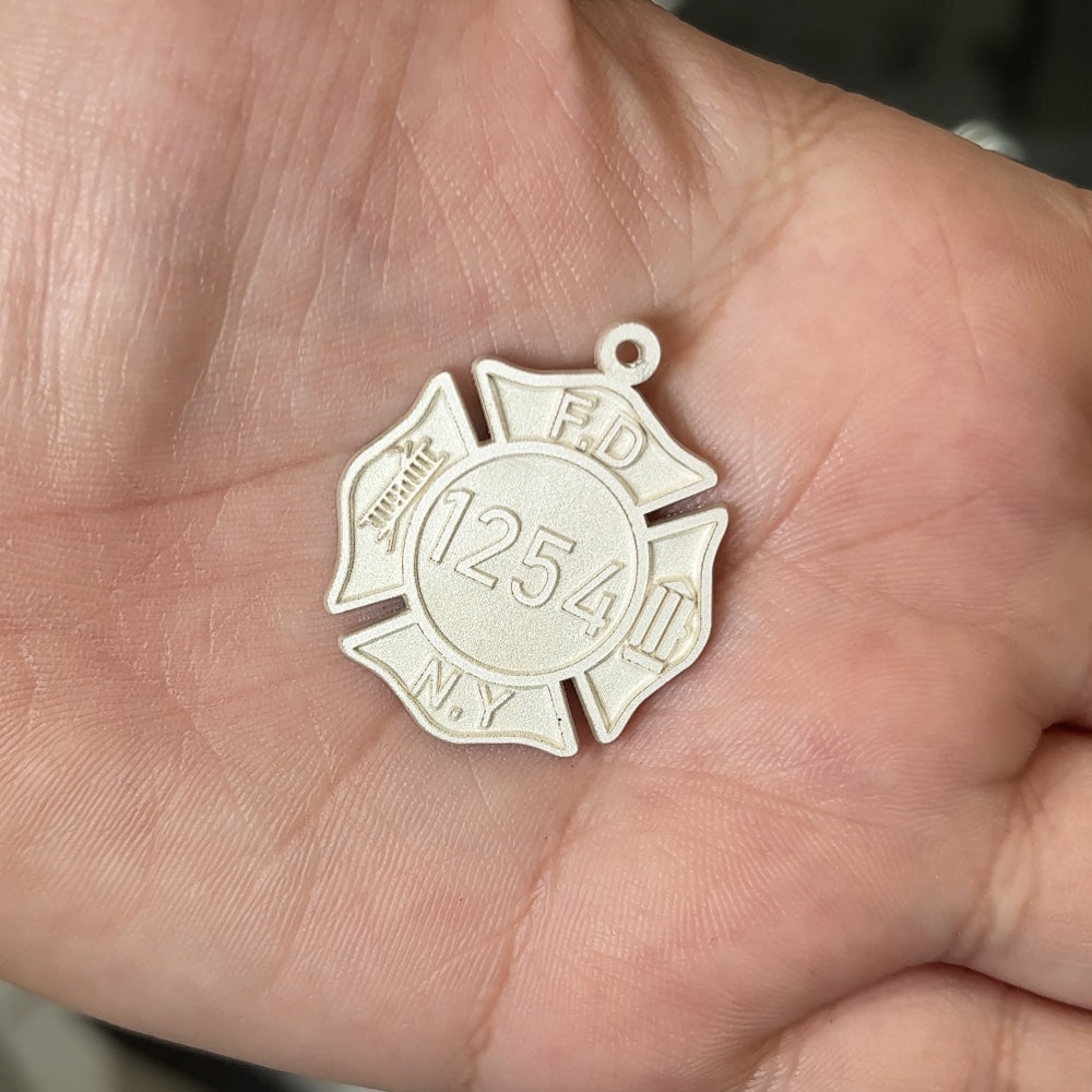 Sterling silver FDNY fire shield pendant after laser engraving and cutting, before hand finishing at AJ's Jewelry Queens NY