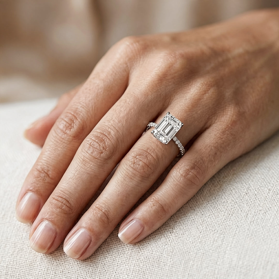 Custom 14KT white gold hidden halo emerald-shape lab-grown diamond engagement ring worn on a hand at AJ's Jewelry in Ridgewood, Queens NY