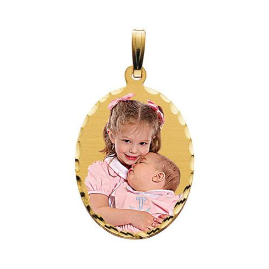 A gold oval shaped pendant with a custom photo of a young girl holding a baby, shown on a plain white background.