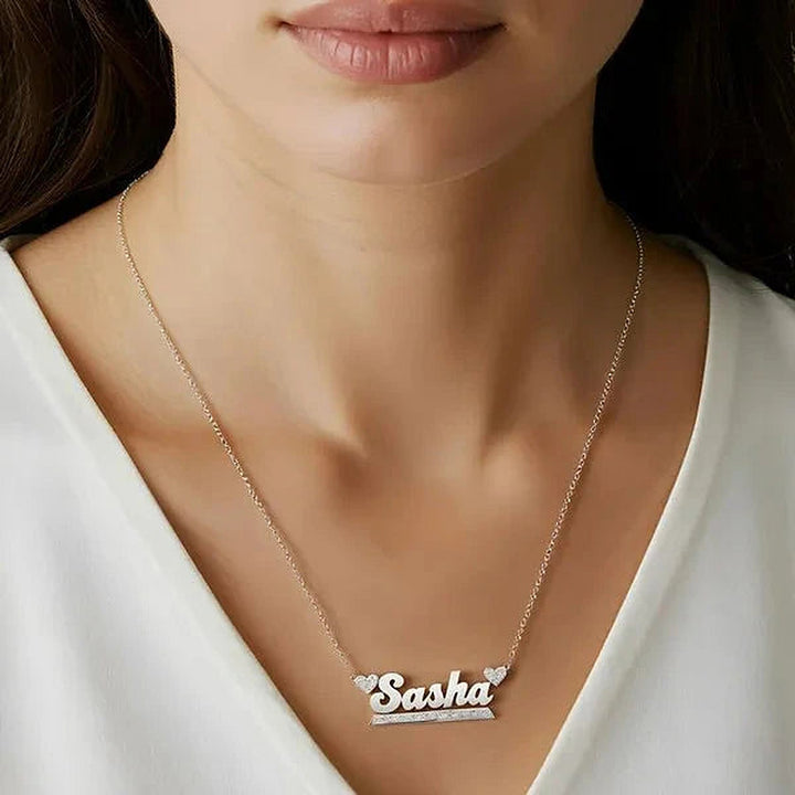Model wearing the 14 Karat Bold Name Necklace with Two Hearts in 14K white gold personalized with the name Sasha | AJ's Jewelry