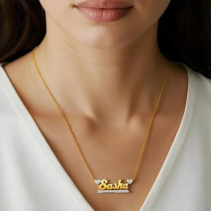 Model wearing the 14 Karat Bold Name Necklace with Two Hearts in 14K yellow gold personalized with the name Sasha | AJ's Jewelry