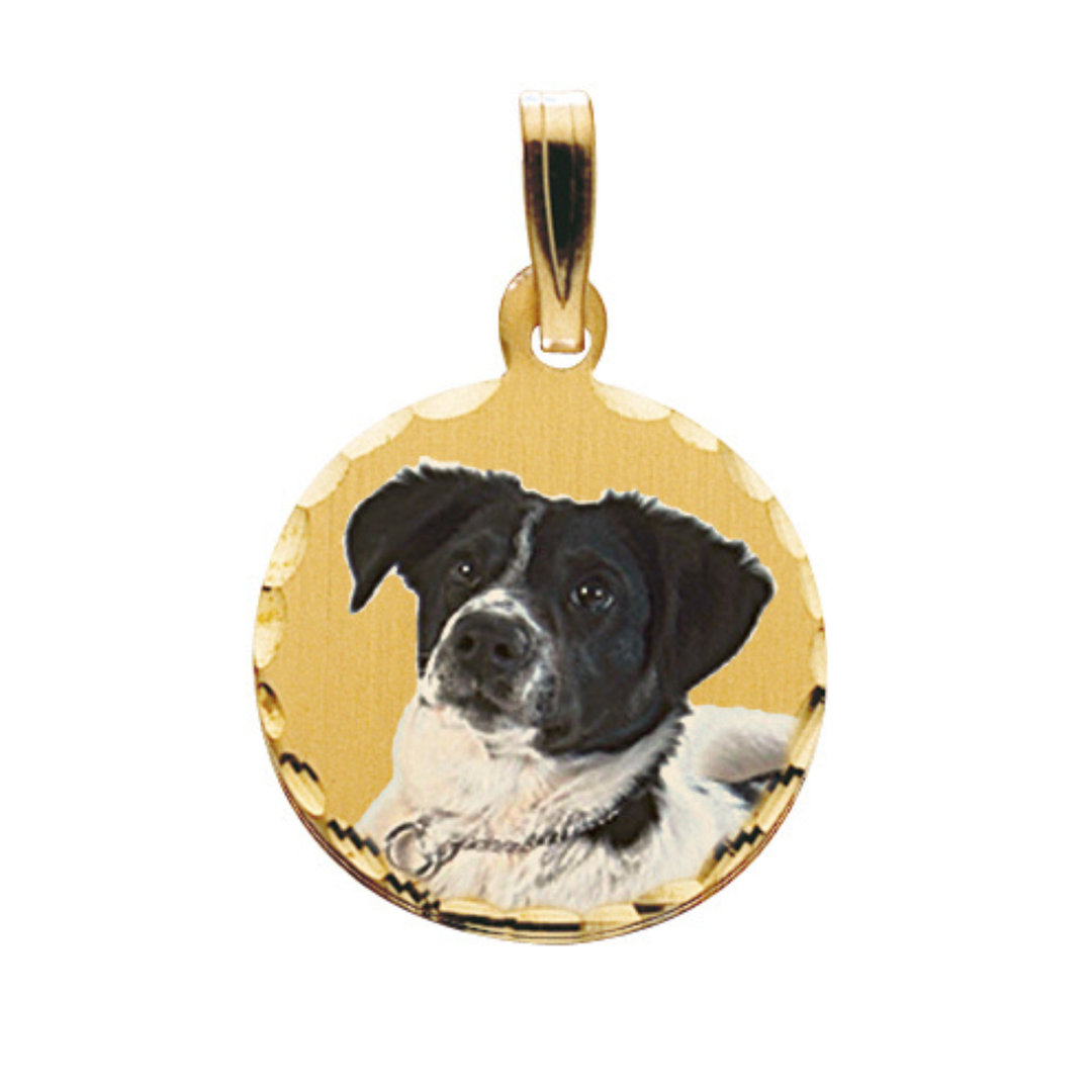 A round gold pendant charm featuring a black and white dog portrait, shown on a plain white background.
