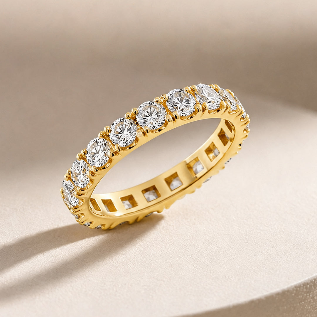 14k yellow gold lab grown diamond eternity band at an angle on a styled display - AJ's Jewelry Queens NY